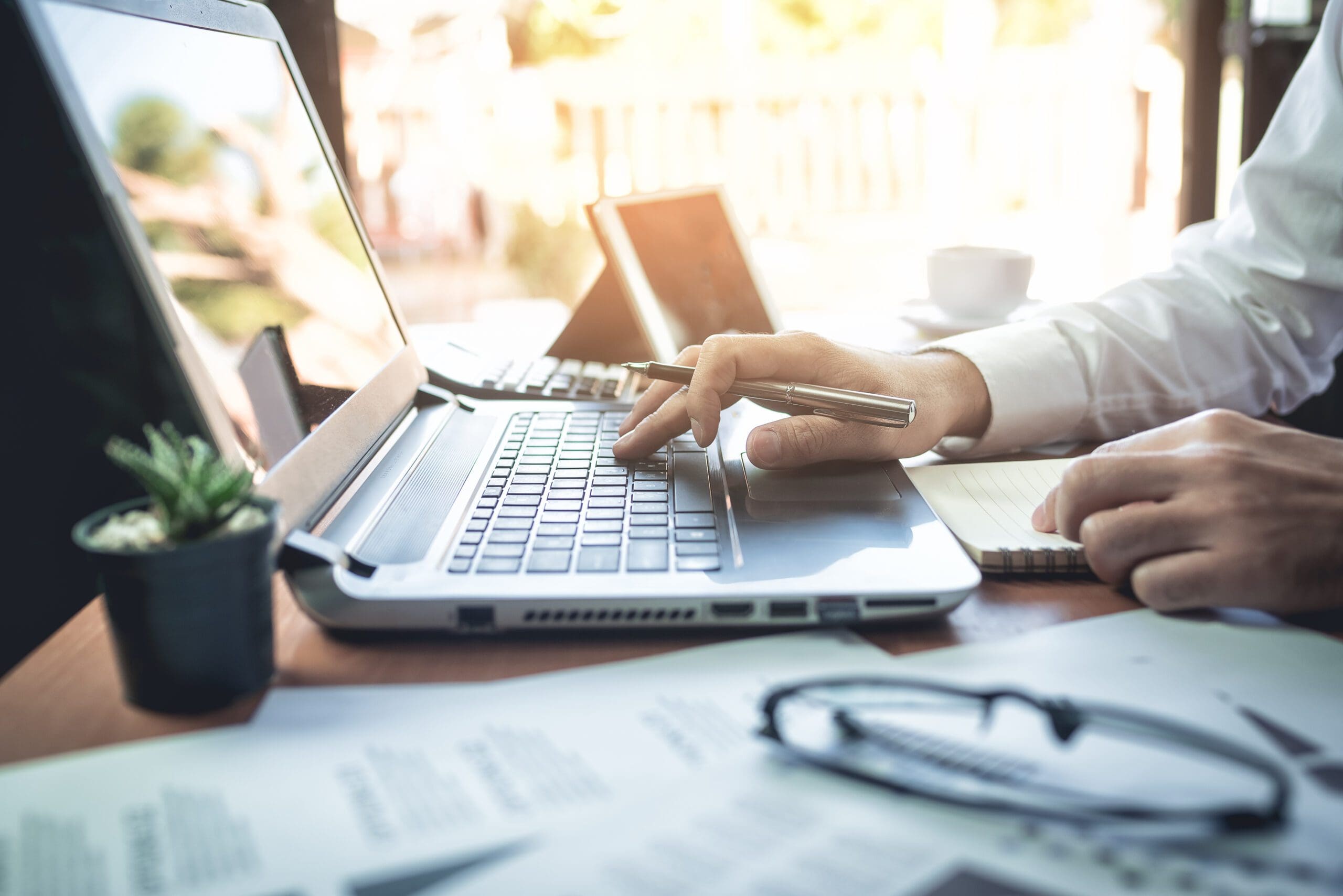 Close up of a laptop and a person working.